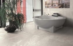 Baie spectaculoasa placata cu gresie imitatie piatra, culoare gri. Gresie Greystone de la Opera Ceramiche cu dimensiunea de 60x120 cm. Adecvata inclusiv la incalzire in pardoseala.